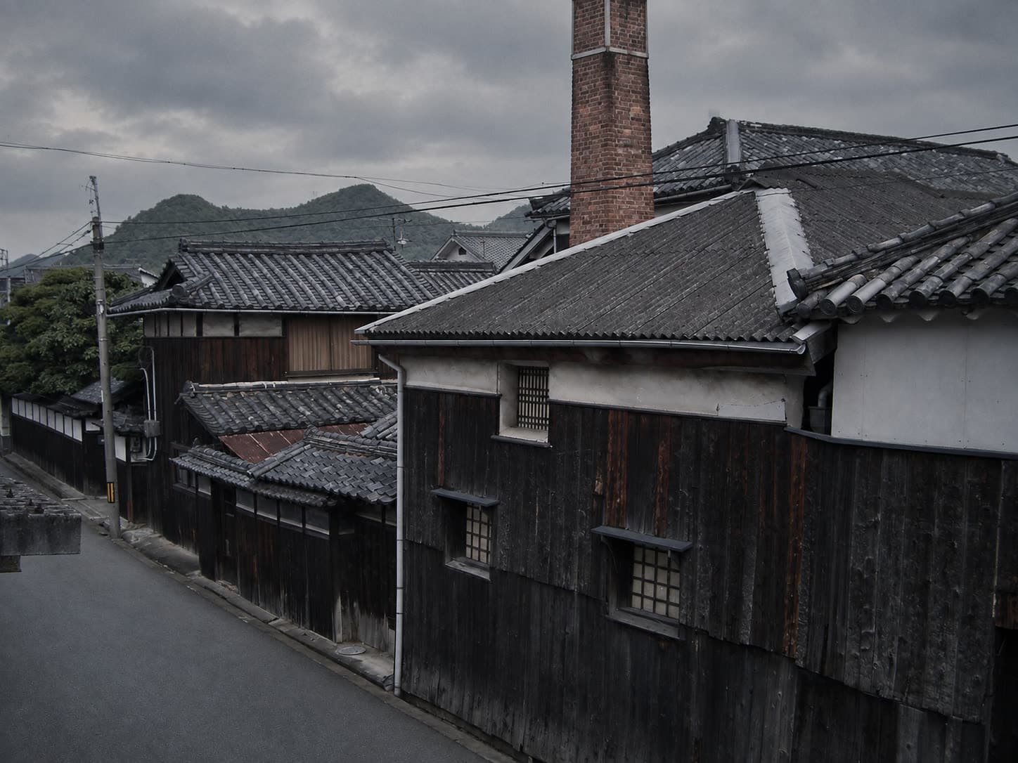 瓦屋根と焼杉の外壁、煉瓦の煙突が残る、在りし日の酒蔵